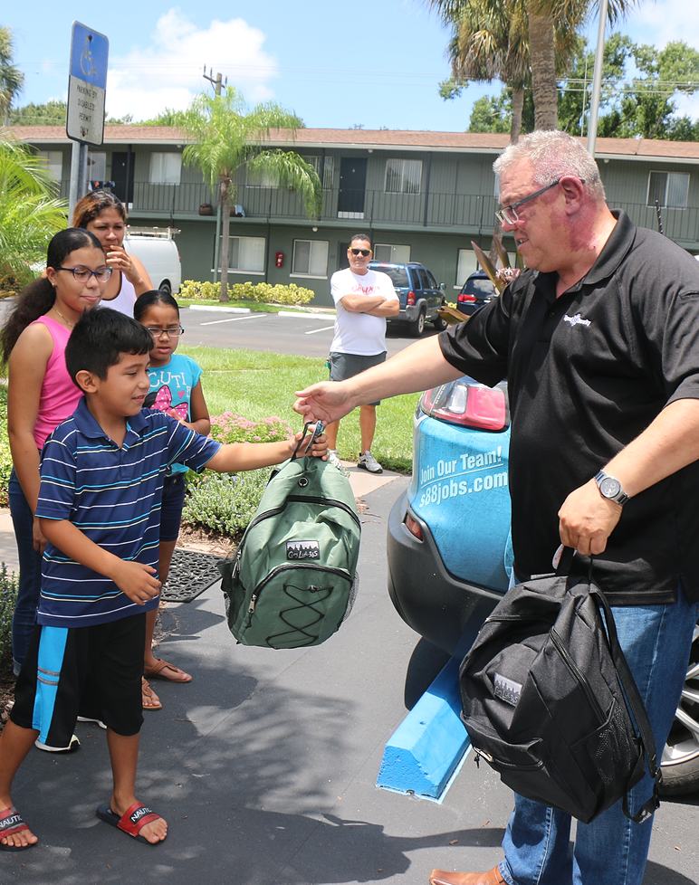 Signal employee handing a duffle bag to a child